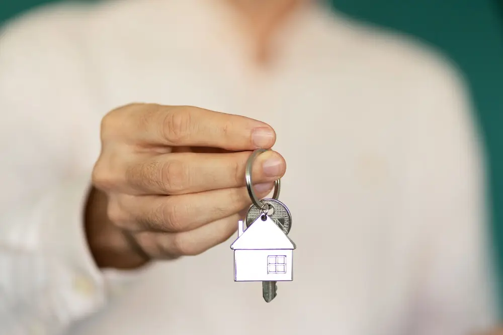 Hausschlüssel vom Immobilienmakler wird gereicht